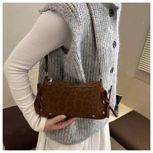Leopard print crescent shoulder bag featuring suede texture and decorative side bow
