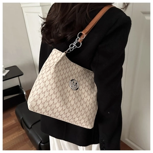 Detail of monogram M print tote bag with silver chain strap and leather handle