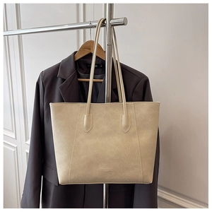 Detail der cremefarbenen Tragetasche mit Retro-Struktur und FASHION & BAGS-Logo