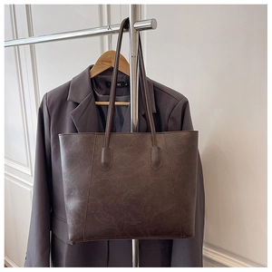 Detailansicht der dunkelbraunen Shopper-Tasche aus Kunstleder mit geprägtem Logo-Schriftzug