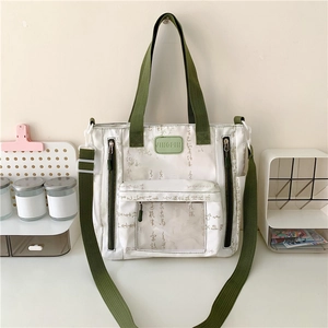 White canvas shoulder bag with green straps and transparent pocket in Neo-Chinese style