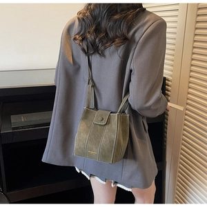 Detail of army green suede crossbody bag with white contrast stitching and gold logo