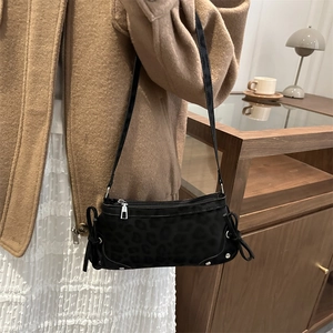 Chic black leopard print crescent shoulder bag with side bows and silver hardware