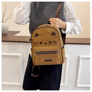 Detail of a mini yellow backpack featuring cute cat ears and fashion brand label detail