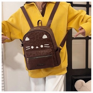 Detail of dark brown leopard print backpack with white kitty cat face embroidery