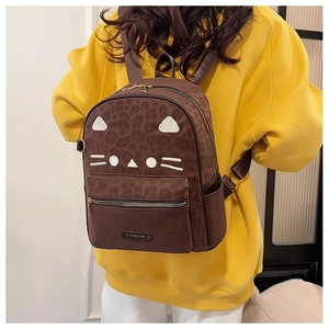 Détail du sac à dos imprimé léopard marron avec broderie chat porté par un modèle