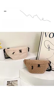 Detail view of large checkered sports sling bags in cream and dark brown fabric