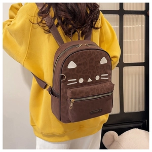 Close-up of a brown leopard print backpack with cute cat embroidery on a yellow hoodie