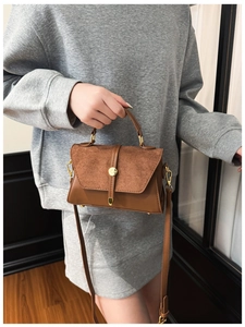 Details der braunen Tasche aus Leder und Wildleder mit runder goldener Metallschnalle