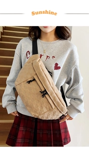 Detail of beige plaid chest bag with waffle texture and adjustable black strap