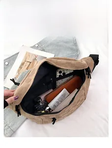 Detail shot of the beige checkered chest bag showing spacious interior with multiple pockets