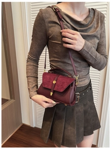 Details von burgunderrotem Leder und Wildleder mit goldener Metallschnalle der Tasche