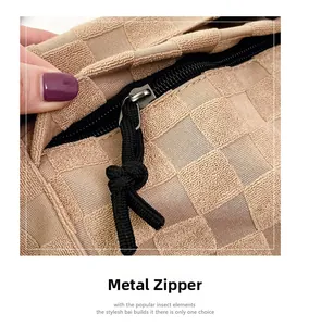 Detail of premium metal zipper with woven puller on beige checkered knit bag