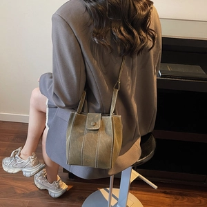 Minimalist olive green bucket bag in matte finish with stylish white stitching details