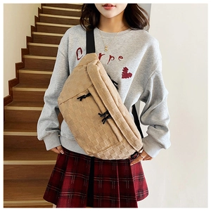 Detail of checkered crossbody bag with black zipper pull and adjustable canvas strap