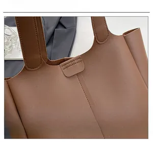 Close-up of brown leather tote bag showing high-quality stitching and smooth texture
