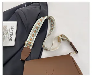 Detail of dark brown leather tote with a colorful geometric jacquard adjustable strap