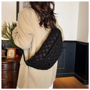 Close-up of black checkered crescent chest bag worn as a crossbody on a model back