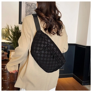 Close-up of black checkered crossbody bag with adjustable strap and textured fabric details