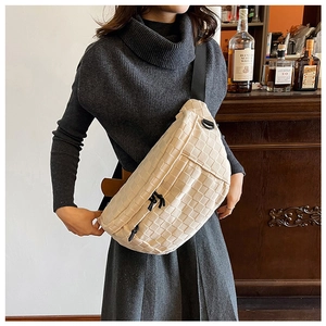 Beige woven crossbody bag detail showing classic checkered texture and wide strap