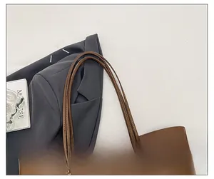Detail view of the durable brown leather multi-strand shoulder strap and gold hardware buckles