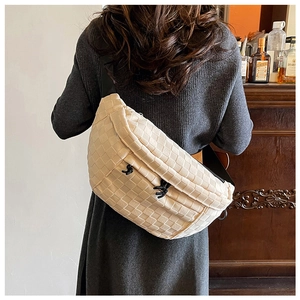 Detail of beige woven checkerboard texture on minimalist crossbody bag with drawstring