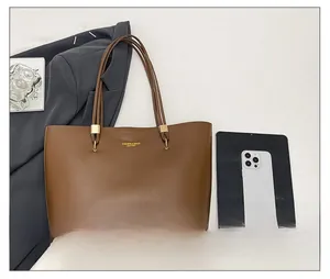 Brown leather tote bag detail with golden hardware and fashion lettering for office use
