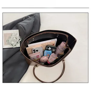Detail view of spacious dark brown tote bag interior filled with everyday essentials