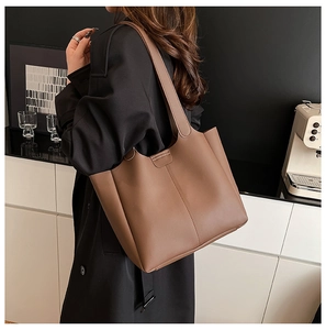 Sac fourre-tout minimaliste marron foncé en cuir mat dans un décor de style de vie urbain