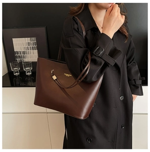 Detail of deep brown PU leather tote bag with gold hardware and slim shoulder straps