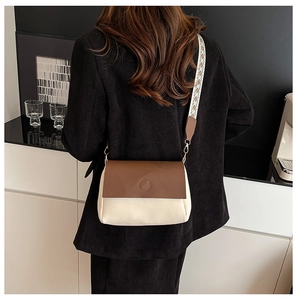 Détail du sac bandoulière minimaliste avec sangle tissée géométrique et texture cuir