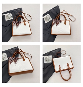 Detail of white snake pattern handbag with contrast brown handles and heart silk scarf