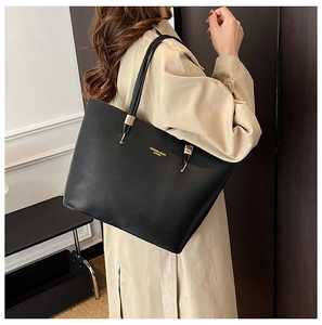 Close-up of black PU leather tote bag with gold lettering and metallic strap details