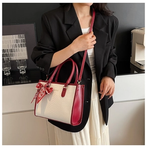 Detail of red and white snakeskin pattern tote bag with decorative silk scarf