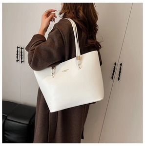 Detailed view of large white PU leather tote bag with long straps worn by a model