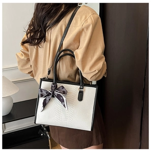 White crocodile pattern bag with black handle and polka dot silk scarf detail