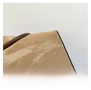 Close-up of light brown bucket bag with high-shine wrinkled texture and coffee handle