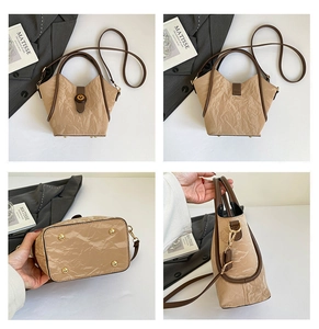 Detail view of khaki handbag showing textured material, metal twist lock and bottom studs