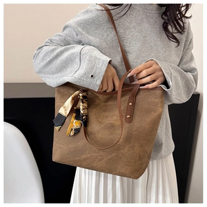 Sac fourre-tout marron vintage avec foulard décoratif porté par un mannequin