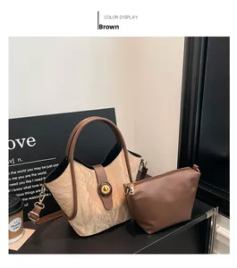 Detailed view of beige textured bucket bag set with brown handles and gold hardware