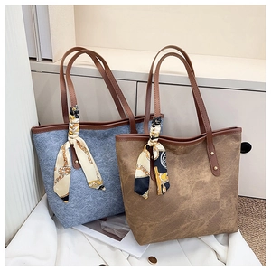 Close-up of matte tote bags with silk scarves and brown leather handles in grey and brown