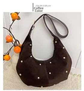 Detail of dark brown hobo bag with gold stud embellishments and suede texture