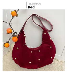 Close-up of wine red velvet hobo bag featuring decorative golden spherical studs
