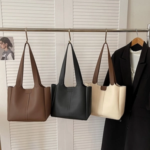 Three minimalist tote bags in brown, black, and beige colors with stylish vertical stitching