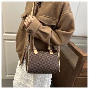 Detailed view of Boston handbag with brown triangle patterns and red edge finish