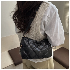 Détail du sac à bandoulière matelassé noir avec finition brillante et sangle réglable