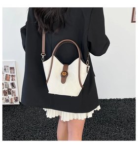 Modelo con bolso bandolera minimalista en crema y marrón con hebilla redonda retro
