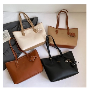 Top view of multi-compartment tote bags in four colors with charms and magazines