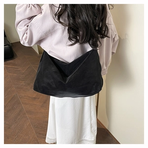 Rear view of model wearing a large black nylon crossbody bag with casual moon shape design