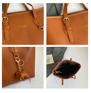 Detail view of brown tote bag featuring gold lettering, elephant charm and inner pockets